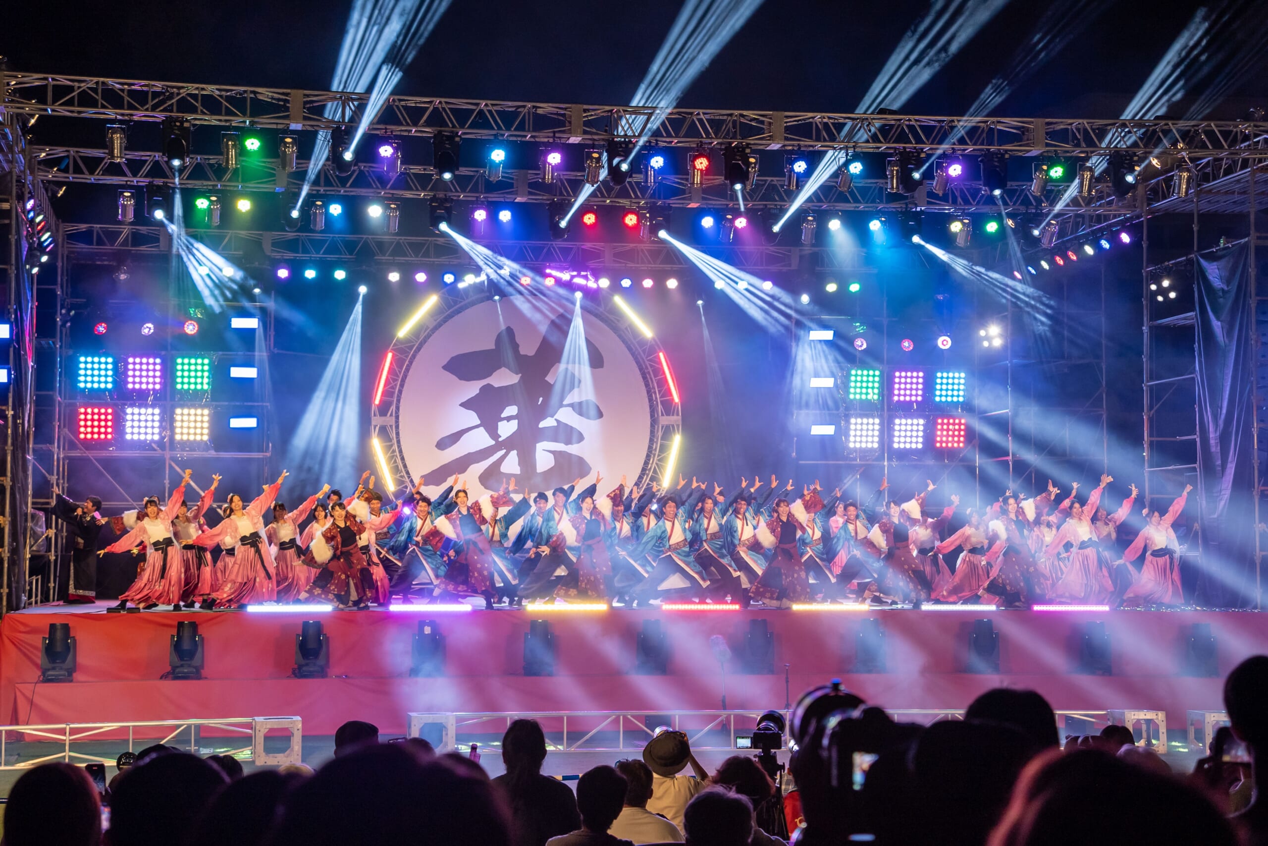 夜の特設ステージで大人数の踊り手が演舞する富山のよさこい祭り